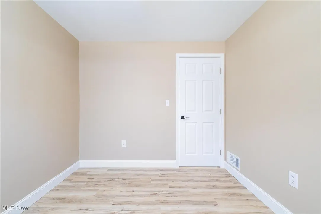 Empty room with light wood-style floors and baseboards