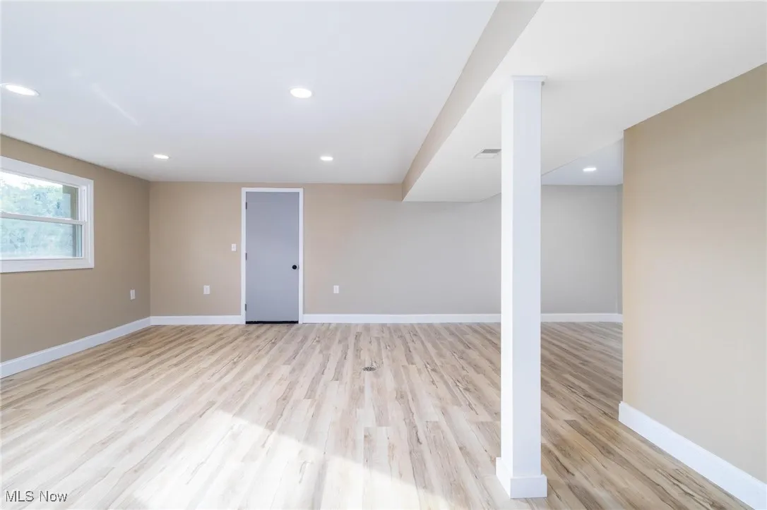 Below grade area featuring light wood finished floors and recessed lighting