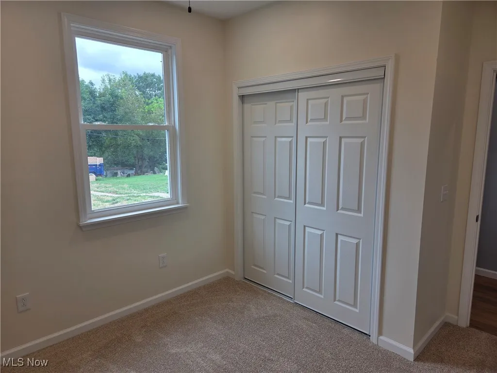 Unfurnished bedroom with carpet flooring and a closet