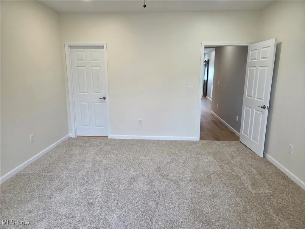 Spare room featuring carpet floors and baseboards