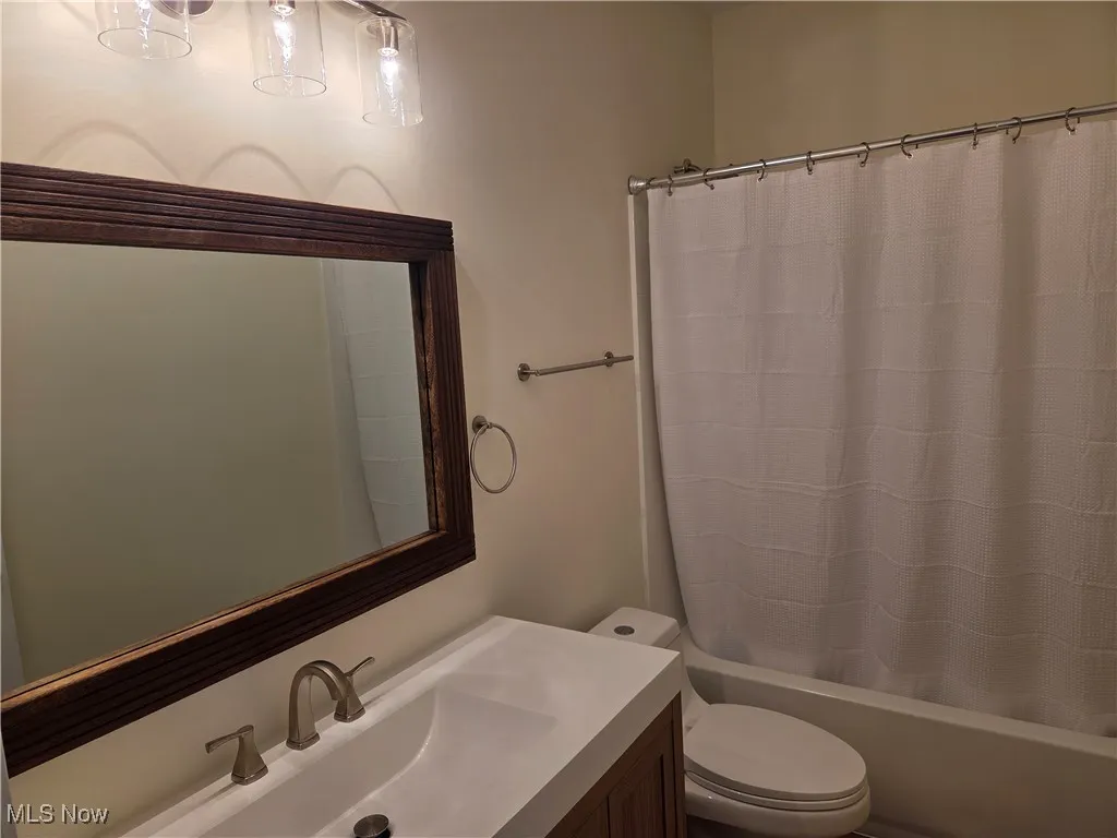 Bathroom with vanity and shower / tub combo with curtain