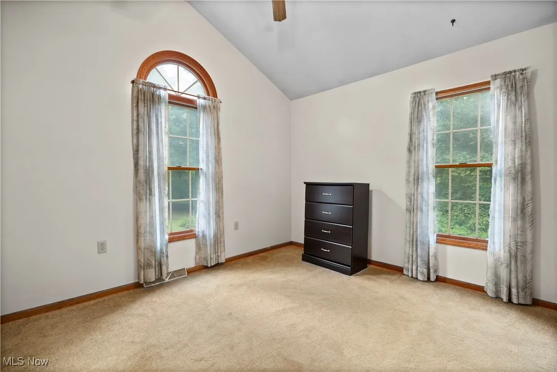 Bedroom with light carpet and windows