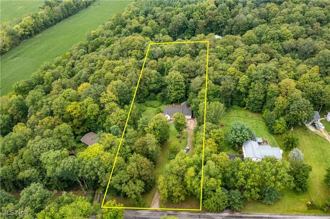 View of property location with property boundaries highlighted and a heavily wooded area