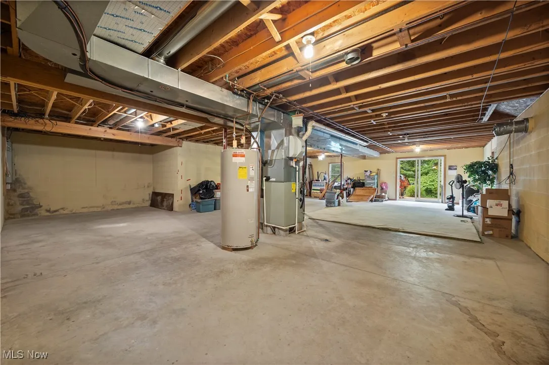 Basement featuring water heater and heating unit