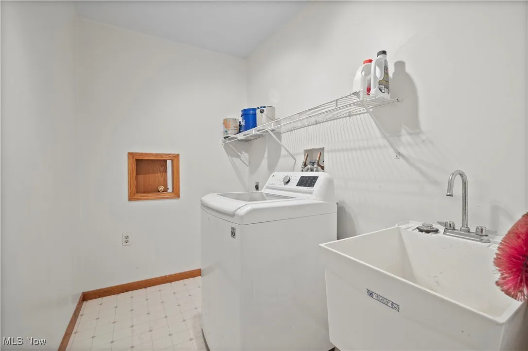Washroom with washer / clothes dryer and light flooring