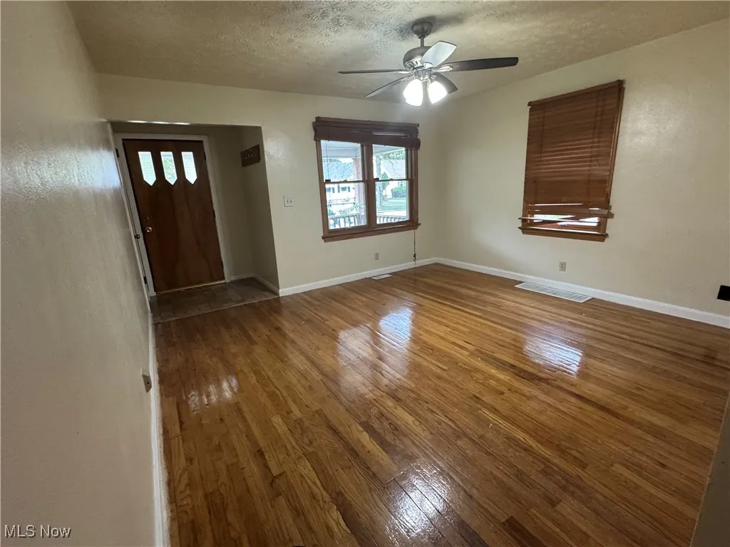 Entryway featuring hardwood / wood-style floors, a textured ceiling, and a ceiling fan