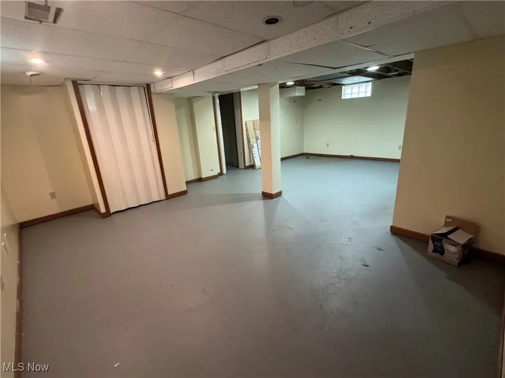 Below grade area featuring baseboards and a paneled ceiling