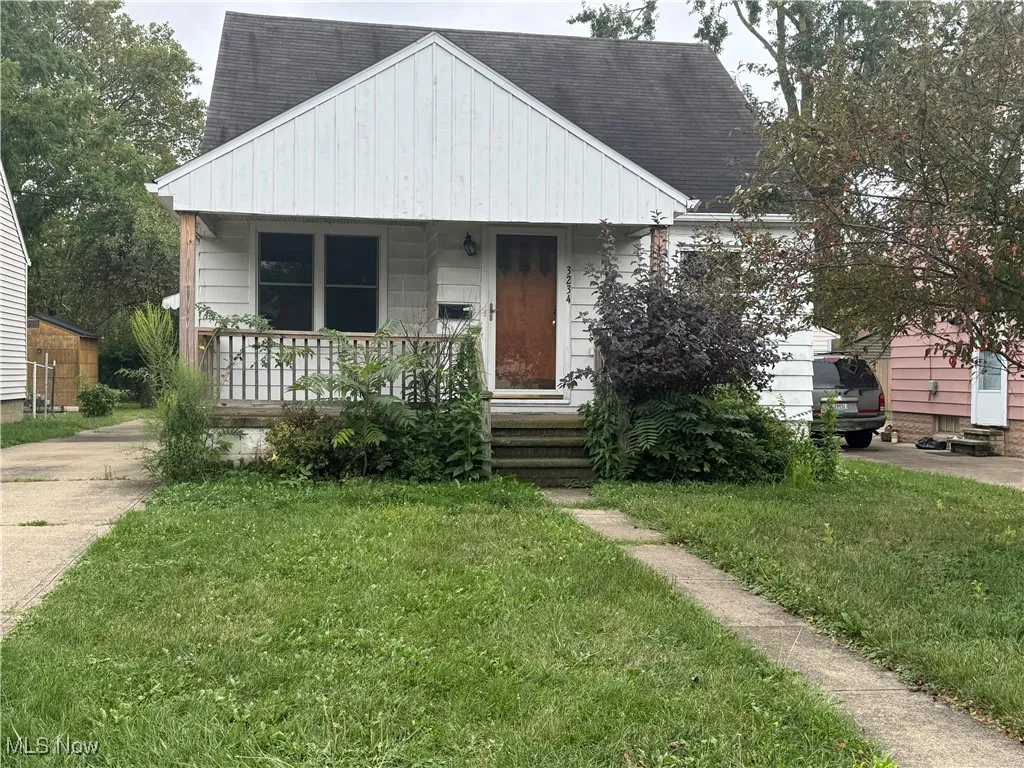 Bungalow-style house with a porch, a shingled roof, and a front yard