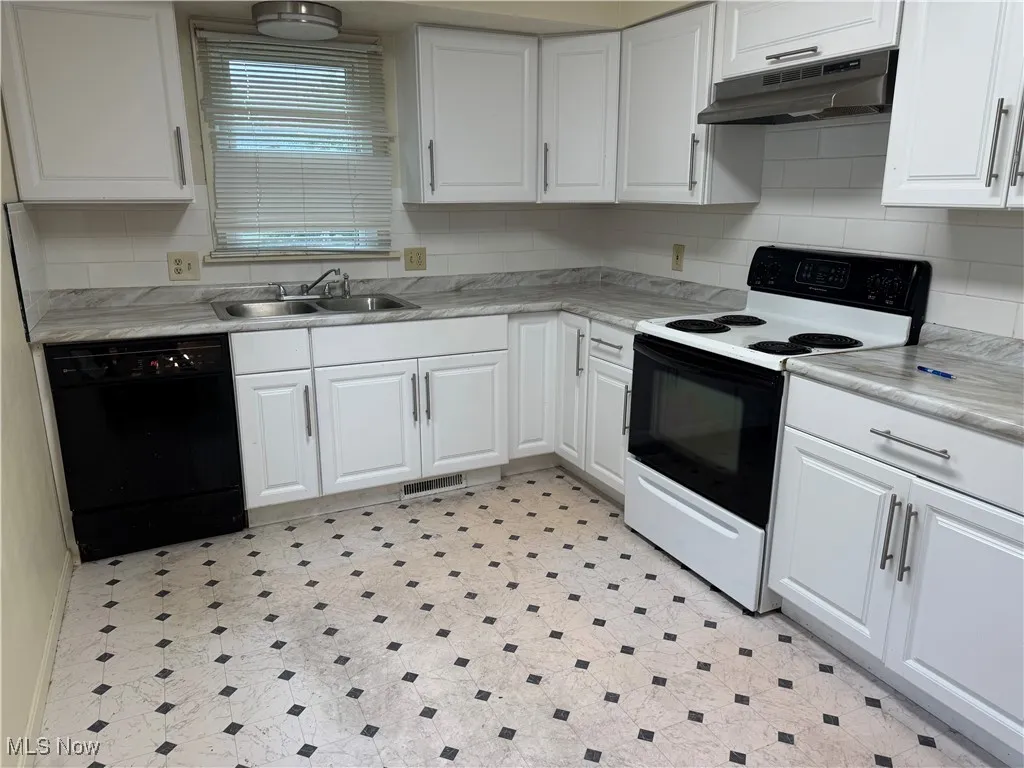 Kitchen featuring white range with electric stovetop and white cabinetry