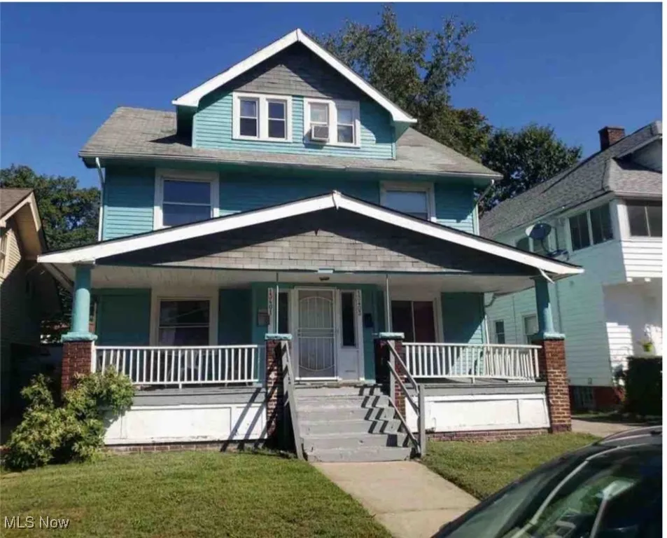 Traditional style home featuring covered porch and a front lawn