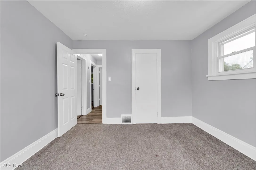 Unfurnished bedroom with carpet floors and baseboards