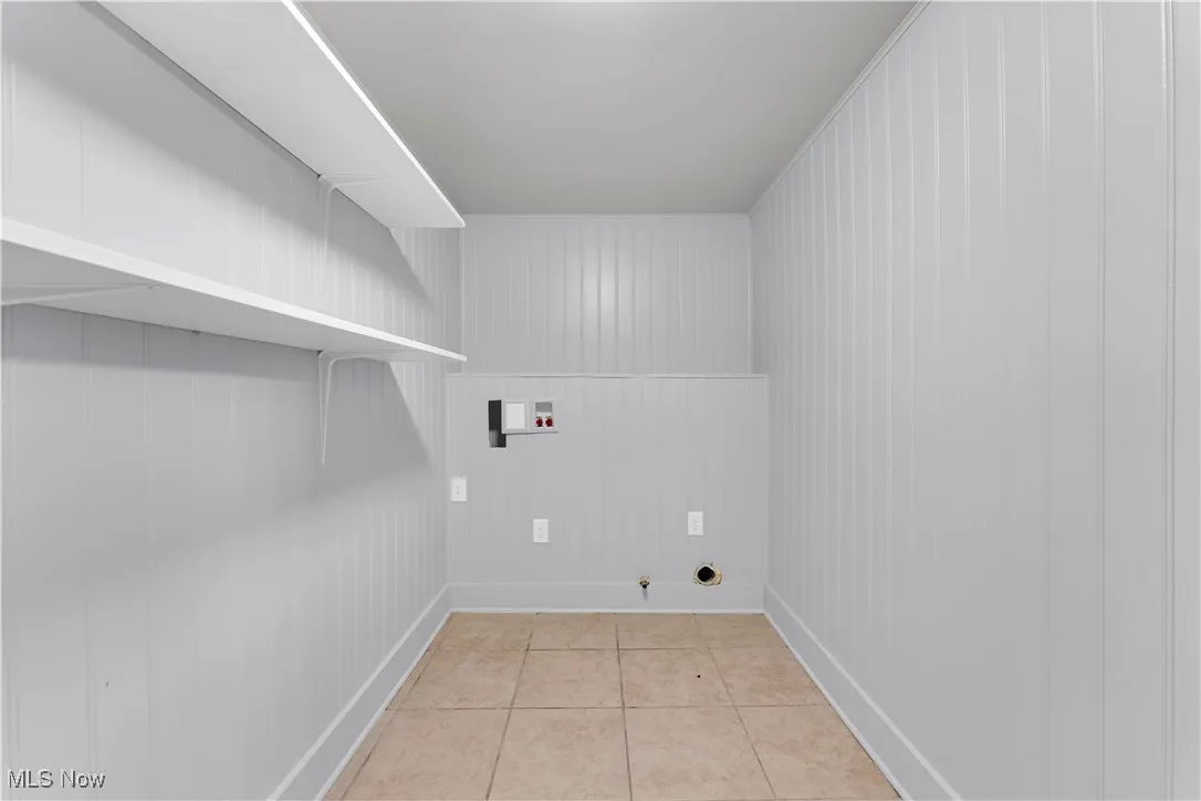 Washroom with light tile patterned floors, hookup for a washing machine, and hookup for a gas dryer