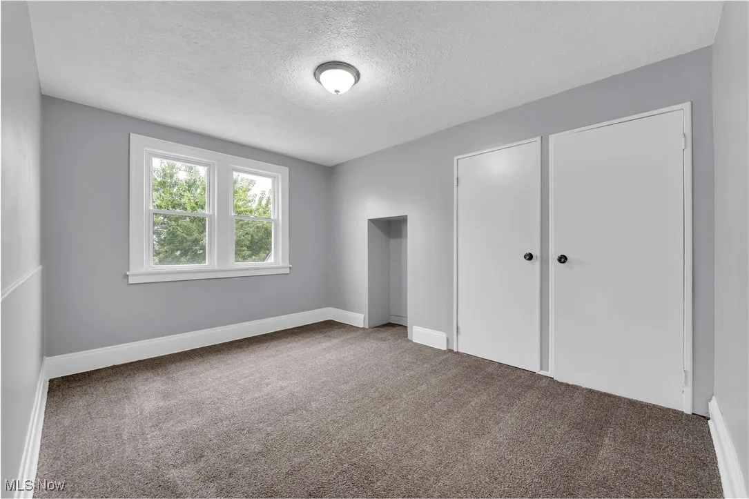 Unfurnished bedroom featuring carpet flooring and a textured ceiling