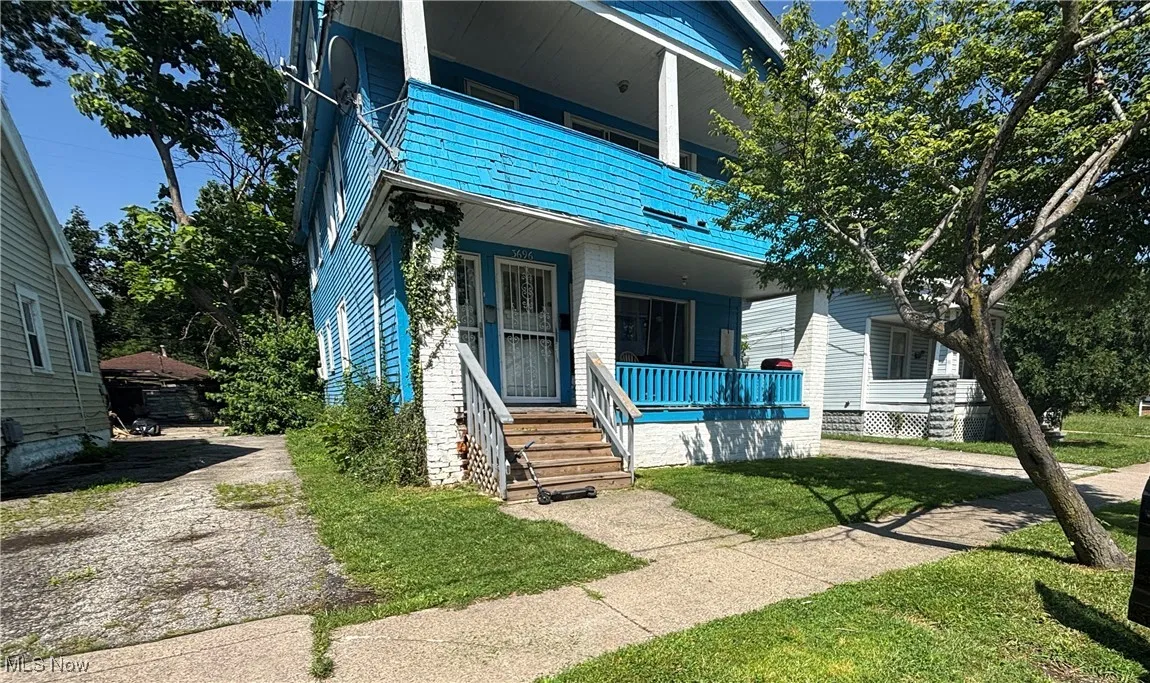 View of front of home with a balcony, a front yard, and a porch