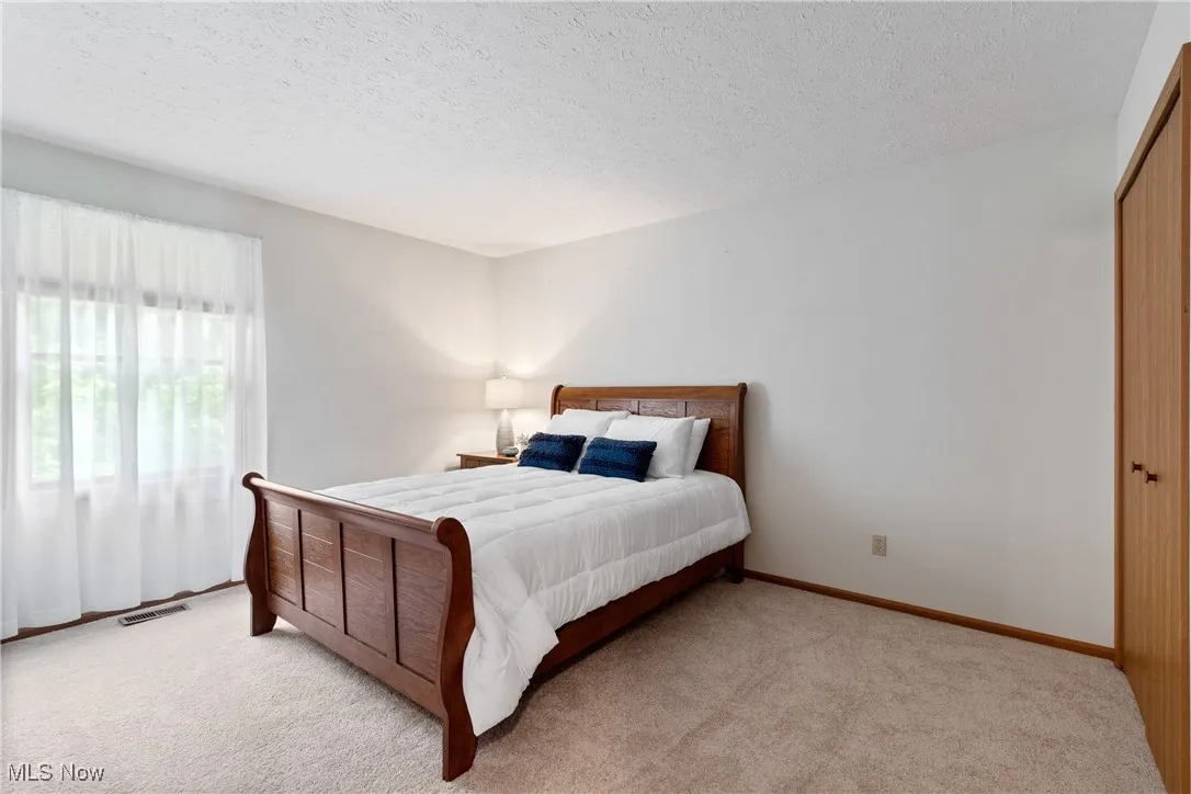 Carpeted bedroom with a textured ceiling and baseboards