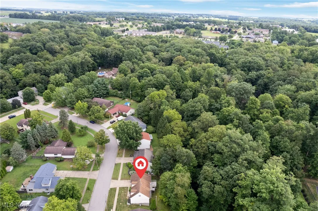 Aerial view of residential area featuring a heavily wooded area