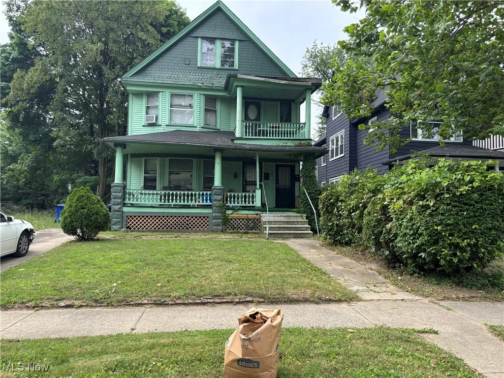 Victorian home featuring a porch and a front yard