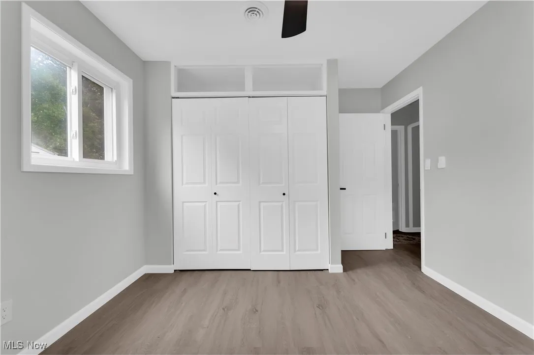 Unfurnished bedroom with wood finished floors, a closet, and ceiling fan