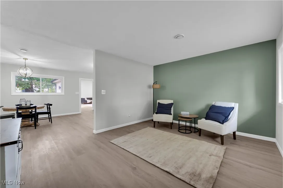 Living area with light wood-style floors and a chandelier