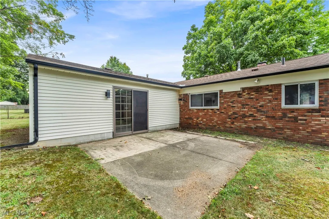 Back of property with a patio area and brick siding