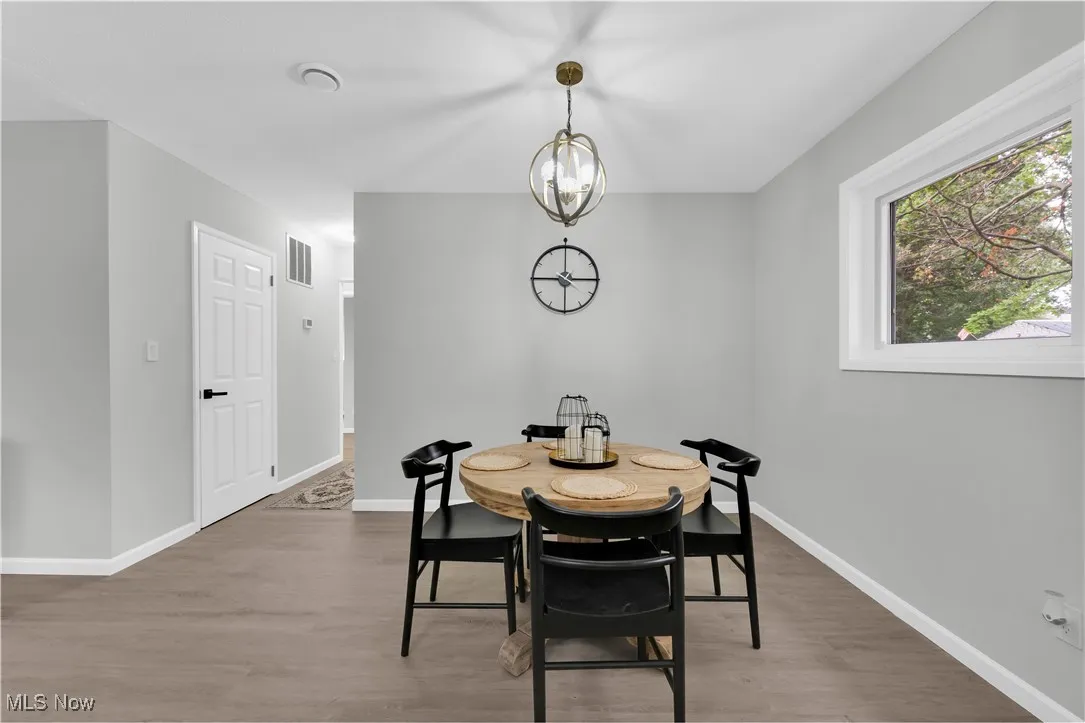 Dining room with wood finished floors and a chandelier
