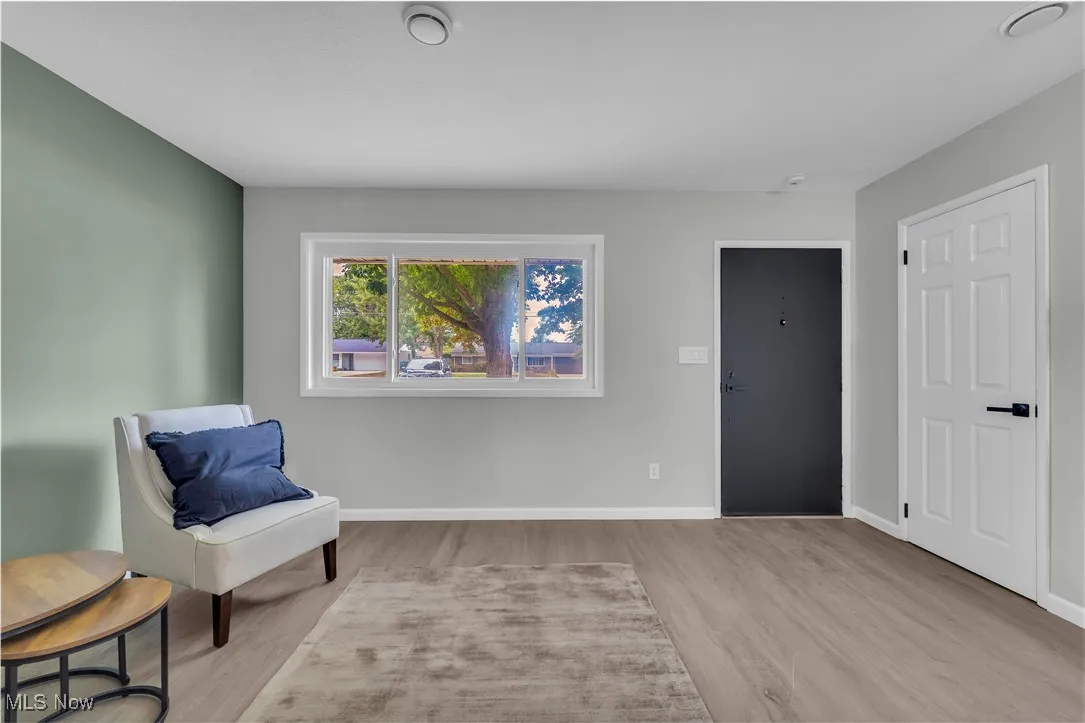 Living area with light wood finished floors and baseboards