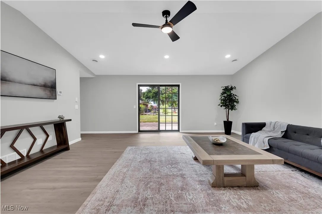 Living area featuring light wood-style flooring, recessed lighting, a ceiling fan, and lofted ceiling
