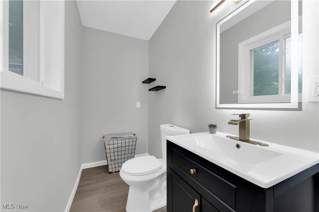 Half bath with vanity and light wood finished floors