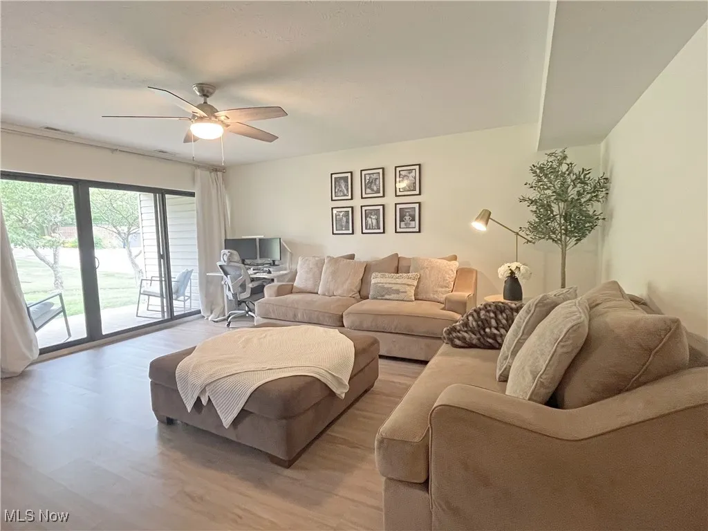 Living room with an office area, wood finished floors, and ceiling fan
