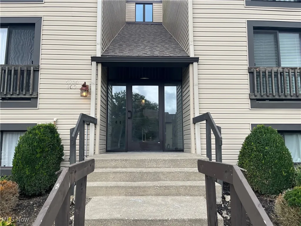 Doorway to property with a shingled roof