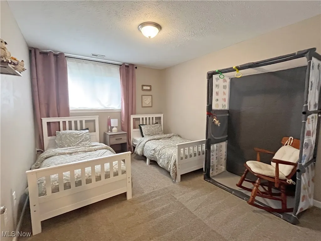 Bedroom with a textured ceiling and carpet floors