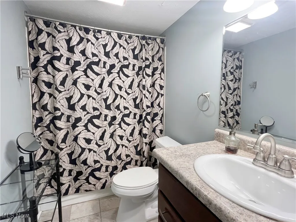 Full bathroom featuring vanity and curtained shower