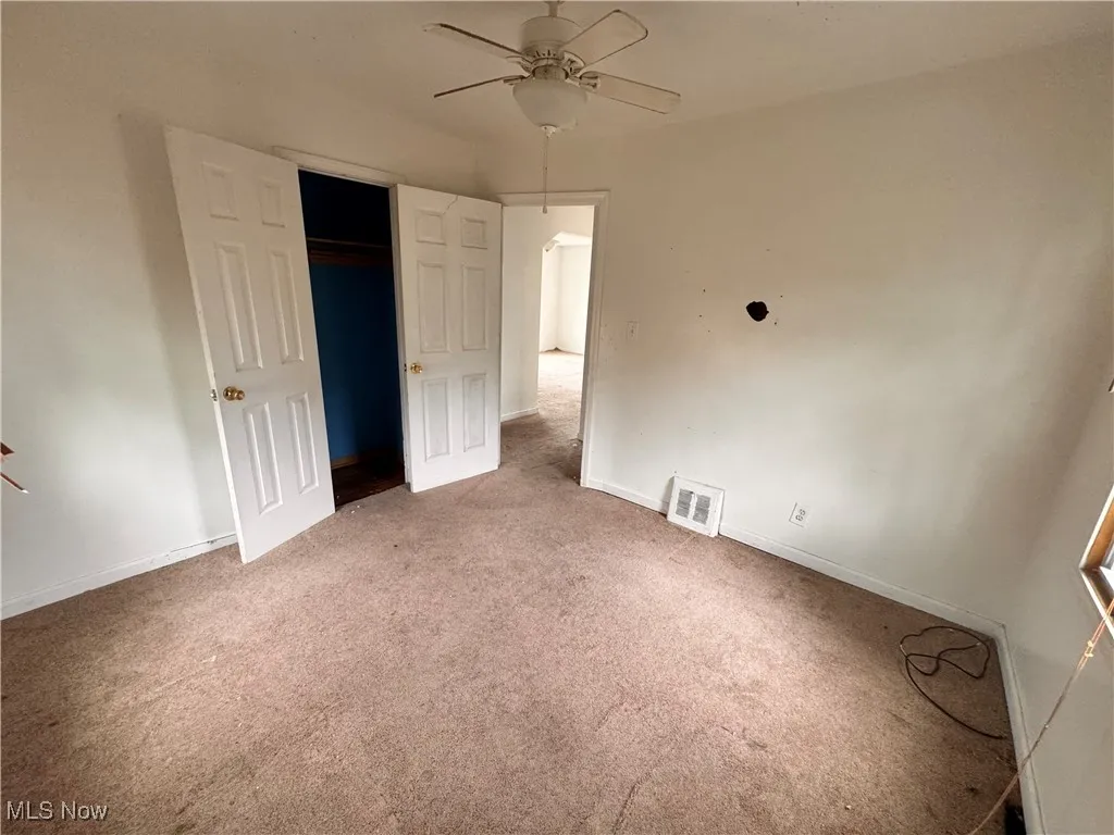 Unfurnished bedroom with carpet floors, ceiling fan, and a closet
