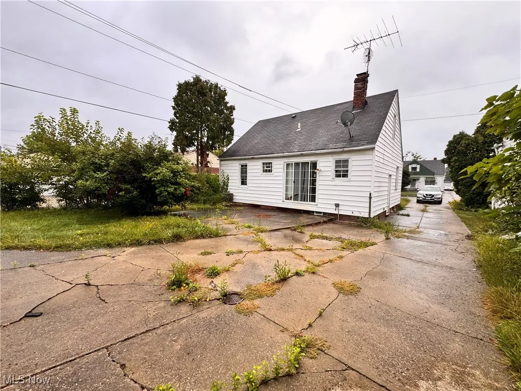 Rear view of property with a chimney, roof with shingles, and a patio