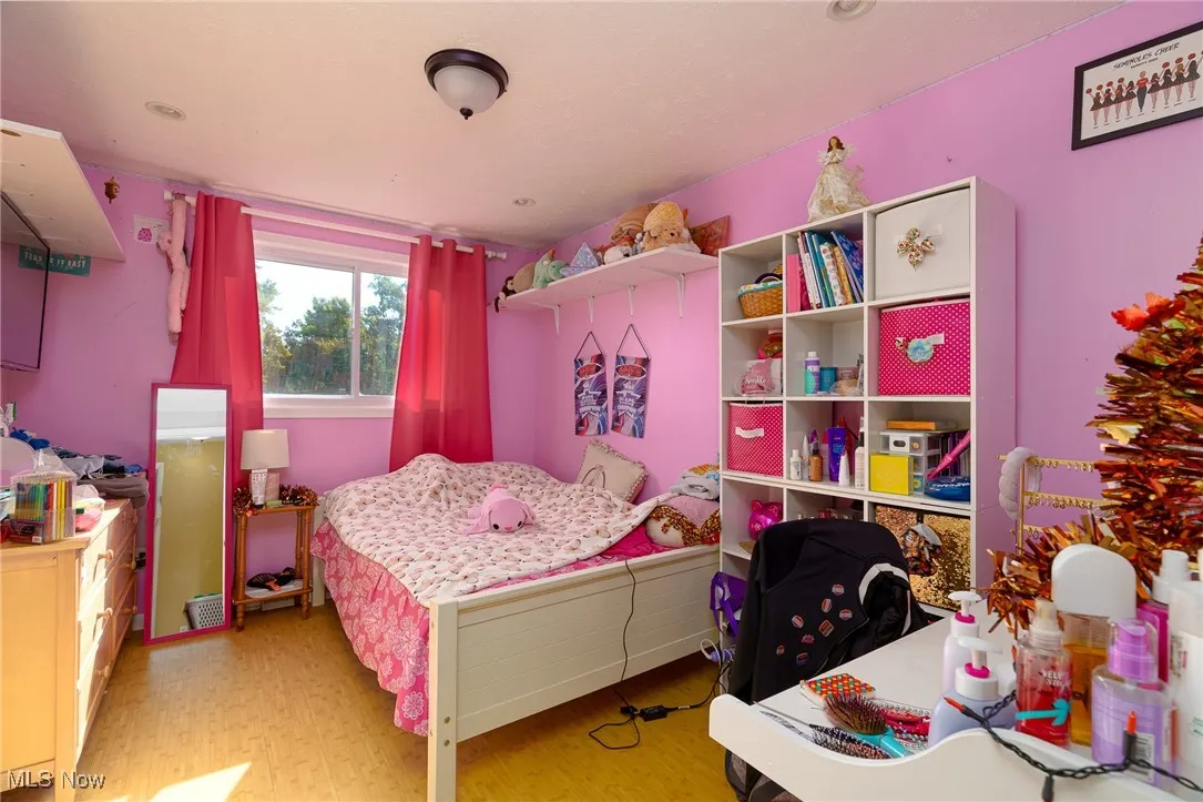 Bedroom #3 featuring light wood finished floors and a window