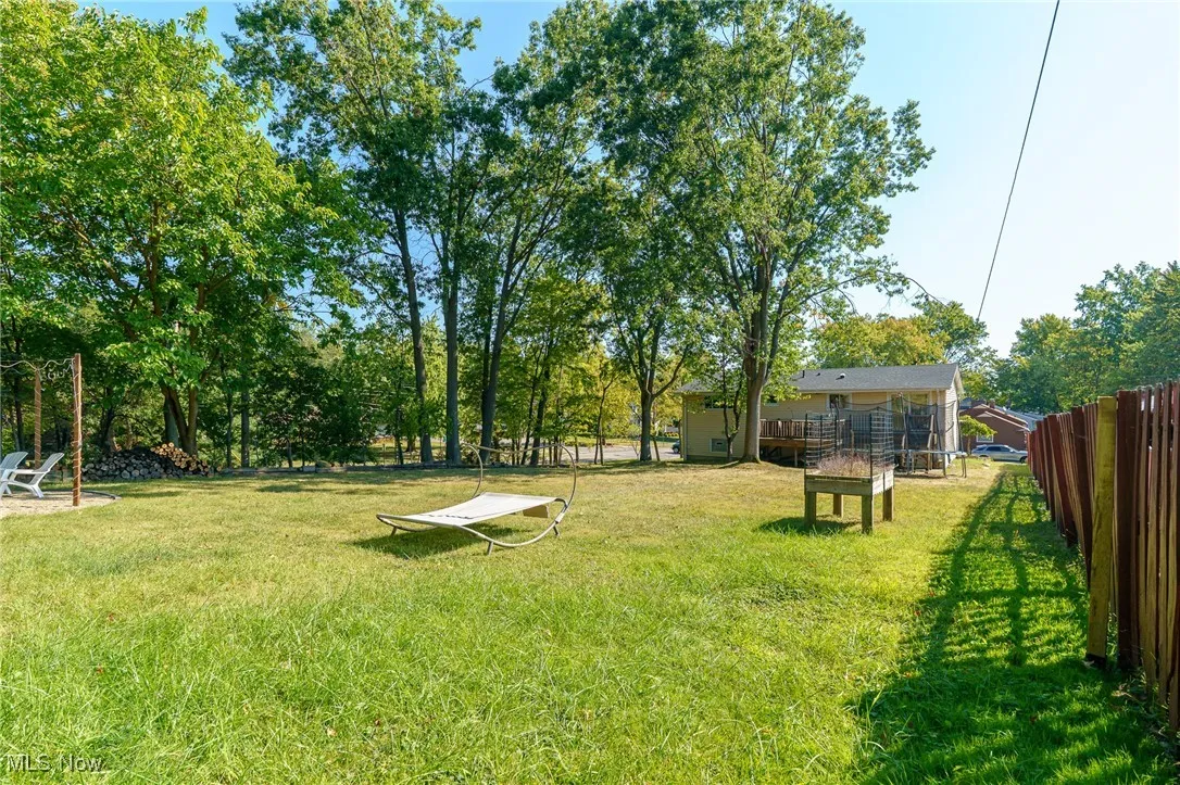 View of yard featuring a wooden deck and view of scattered trees