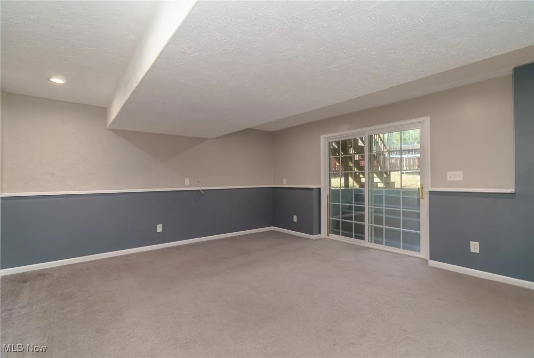 Family room featuring a textured ceiling, carpet flooring, and walk out to back yard