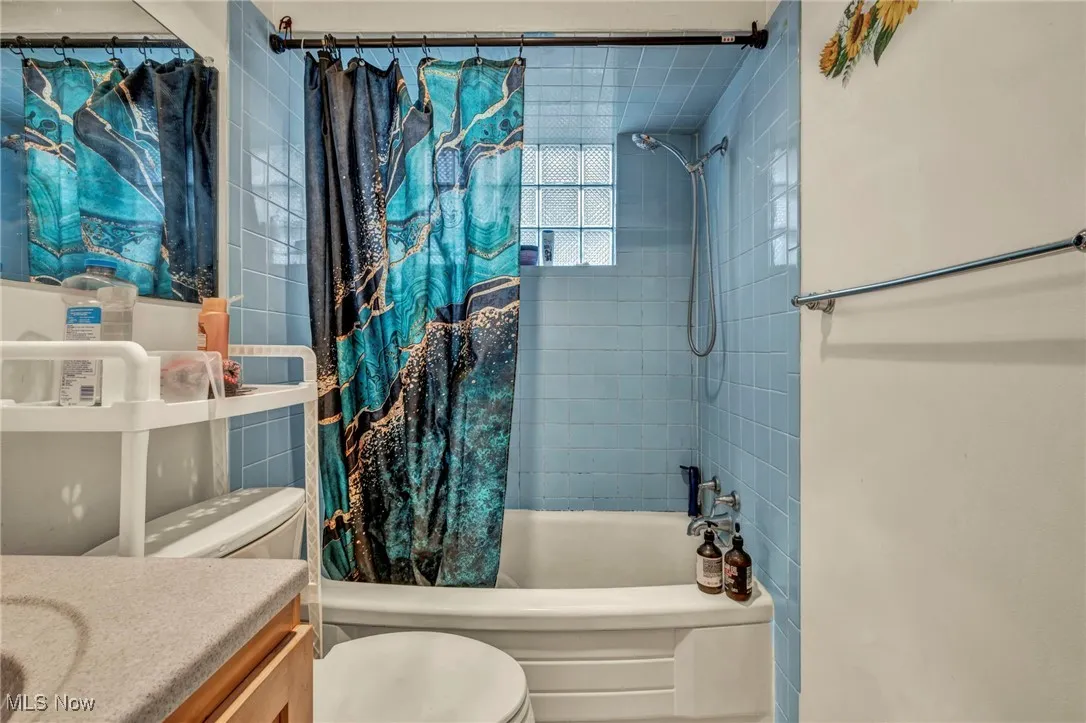 Bathroom with shower / bath combo and vanity