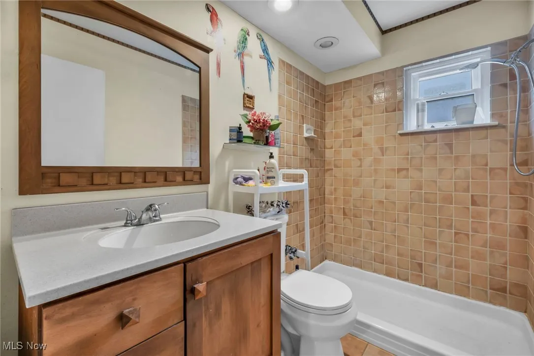 Full bath with vanity and tiled shower