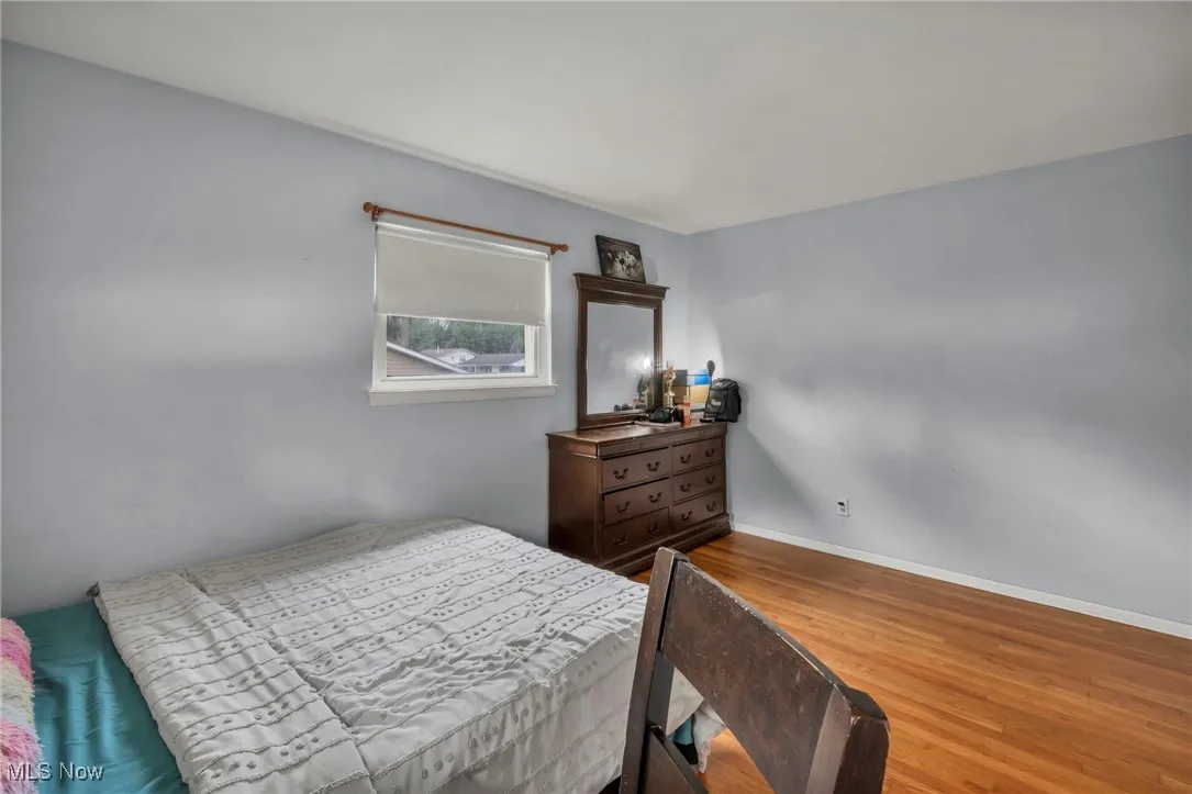Bedroom featuring wood finished floors and baseboards