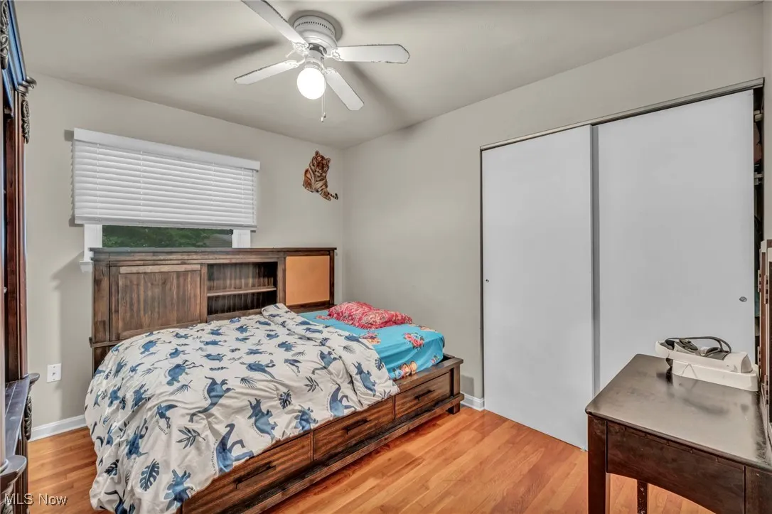 Bedroom with a closet, light wood-style floors, and ceiling fan