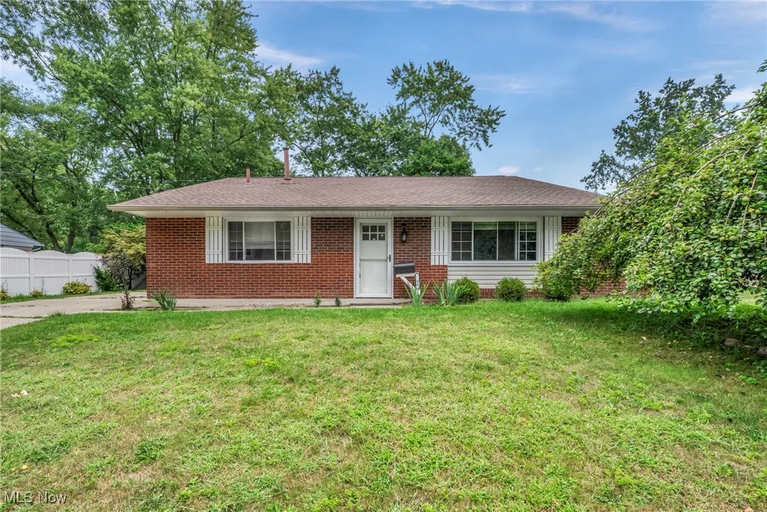 Ranch-style home featuring a front yard, brick siding, and roof with shingles