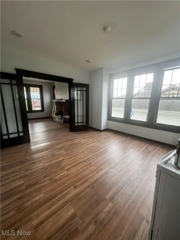 Unfurnished living room with wood finished floors and baseboards