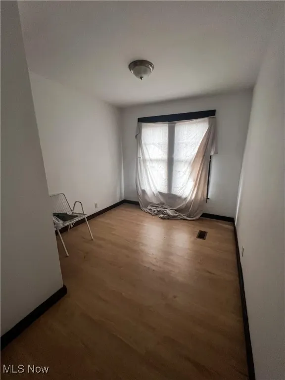 Spare room featuring wood finished floors and baseboards