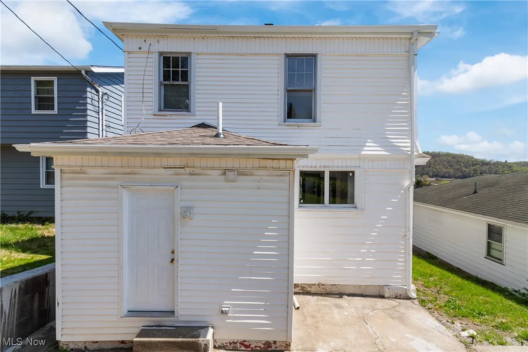 Back of property with roof with shingles
