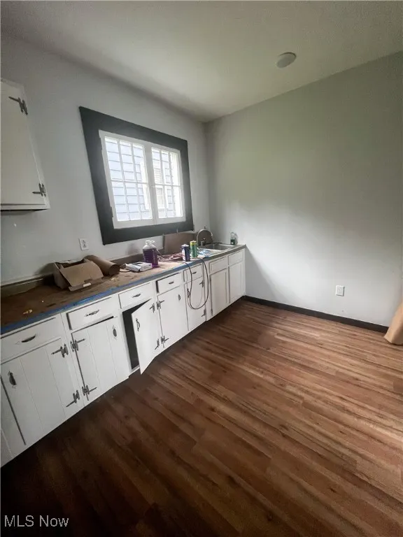 Kitchen with white cabinetry and dark wood-style flooring