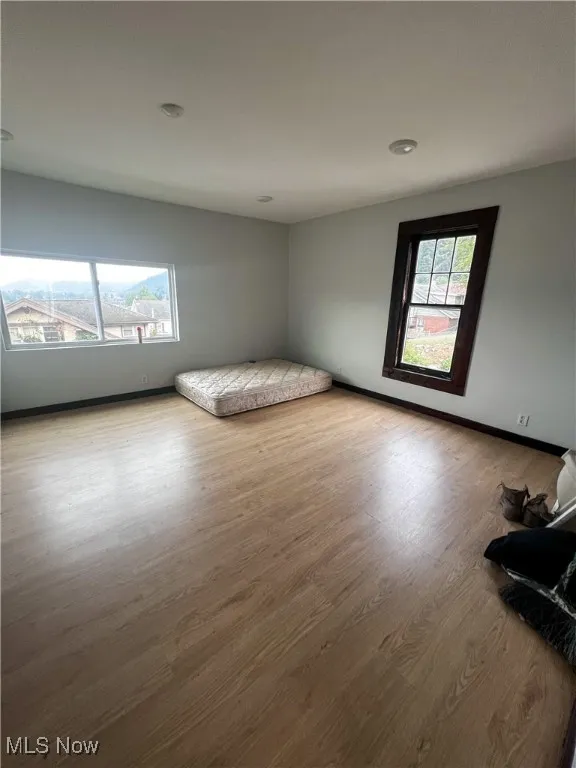Unfurnished bedroom featuring light wood-type flooring and baseboards