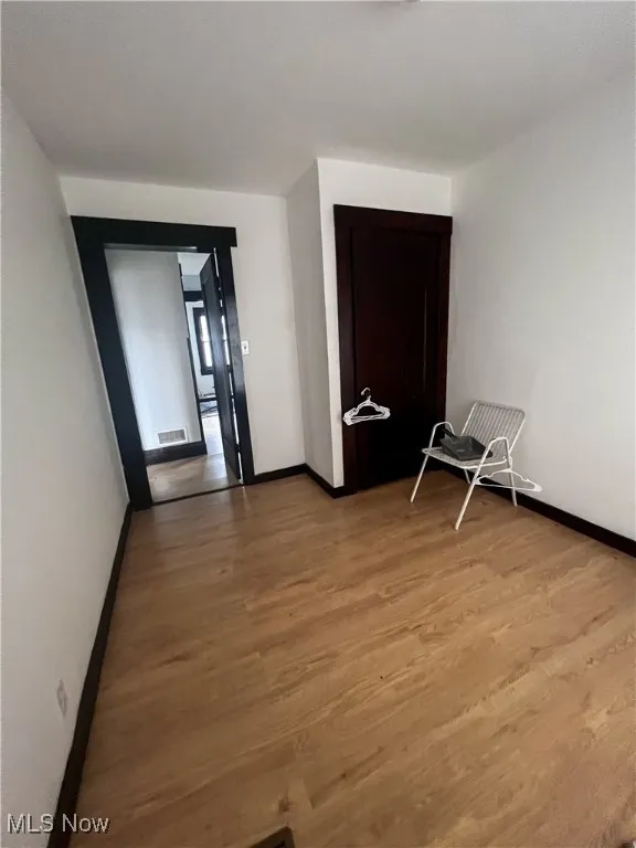 Empty room featuring baseboards and light wood finished floors