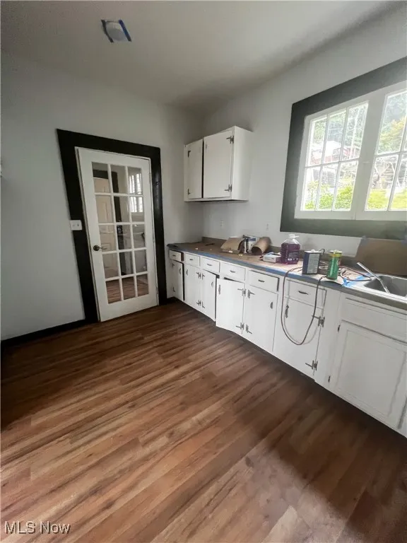 Kitchen featuring white cabinetry, dark wood-style floors, and dark countertops