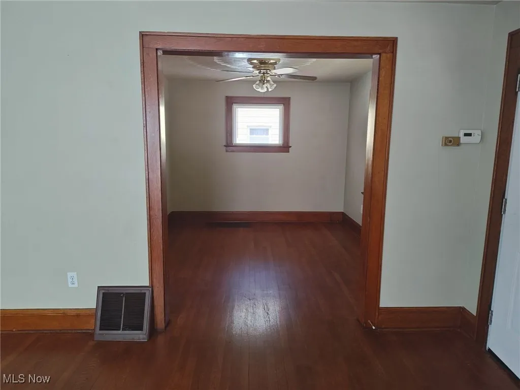 Hallway featuring baseboards and dark wood-style flooring